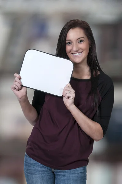 Mujer sosteniendo un signo en blanco — Foto de Stock