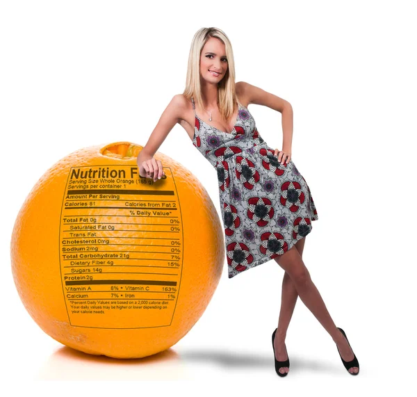 Femme penchée sur l'orange avec étiquette nutritionnelle — Photo