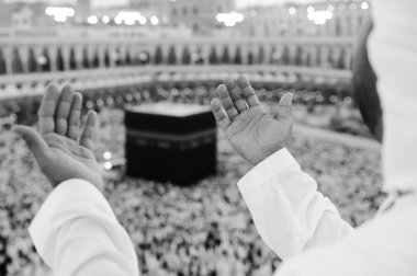 Muslim praying at Mekkah with hands up clipart