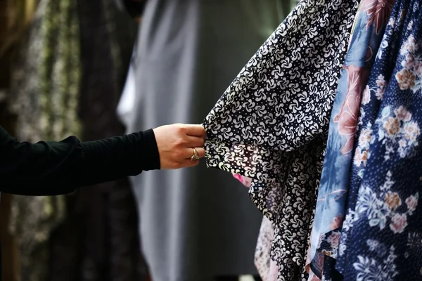 Женщина выбирает одежду на рынке — стоковое фото