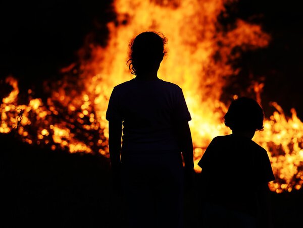 Two children looking at big fire