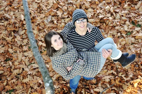 Casal adolescente romântico por árvore no parque de outono — Fotografia de Stock