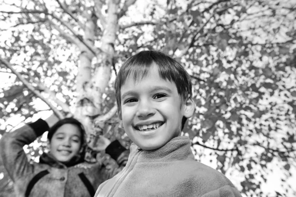 Happy kid och höstlöv i en park — Stockfoto