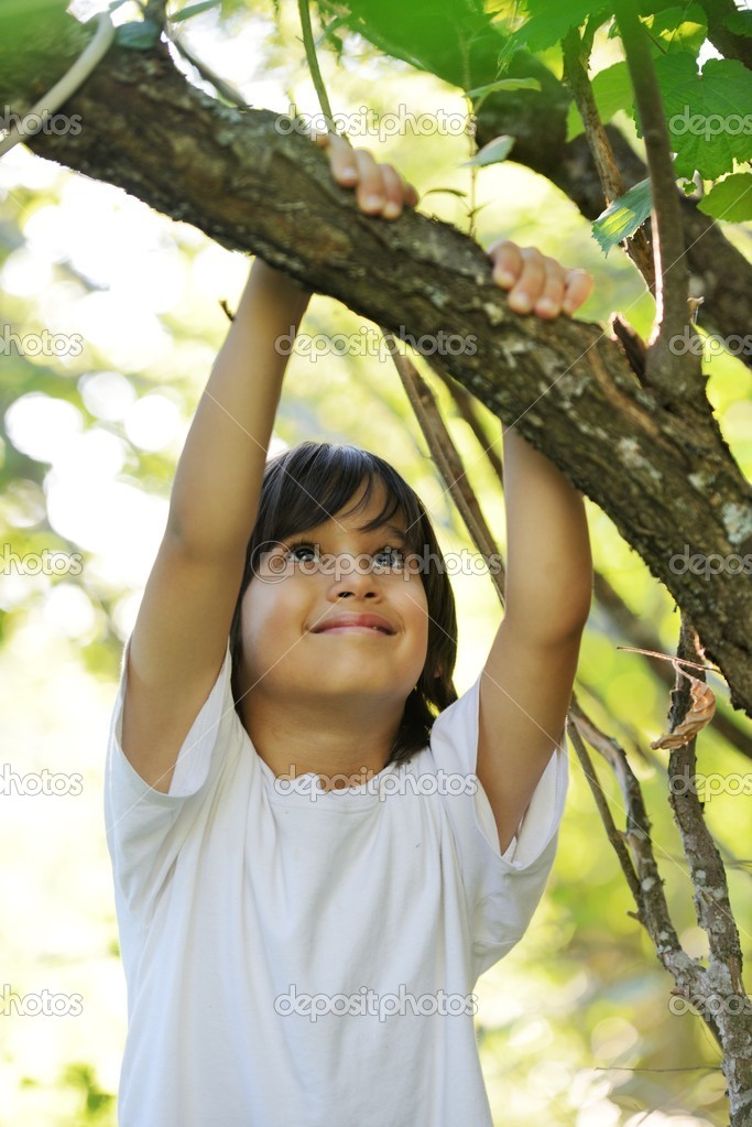 Child in nature holding tree arm