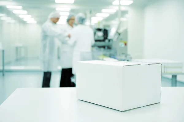 Caixa branca na linha de produção automatizada na fábrica moderna pronta para o seu logotipo — Fotografia de Stock