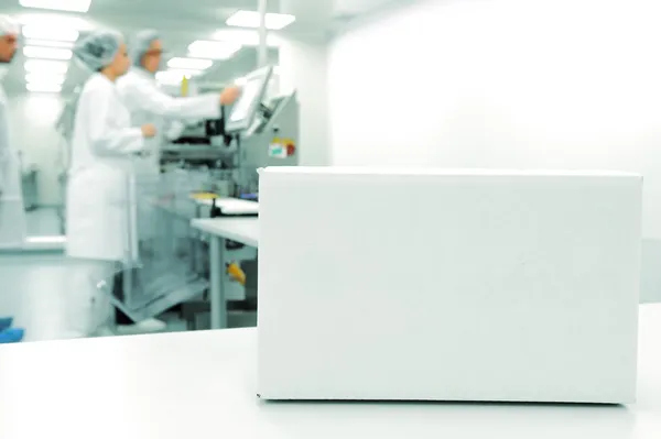 Caixa branca na linha de produção automatizada na fábrica moderna, trabalhando em segundo plano — Fotografia de Stock