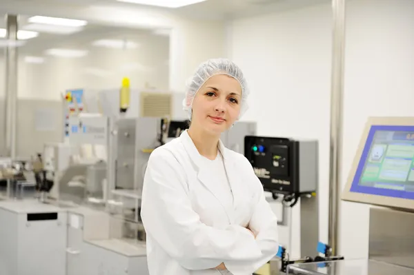 Mulher trabalhadora na linha de produção automatizada na fábrica moderna Imagem De Stock