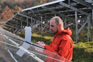 erkek mühendis dizüstü, güneş panelleri arka planı olarak kullanma