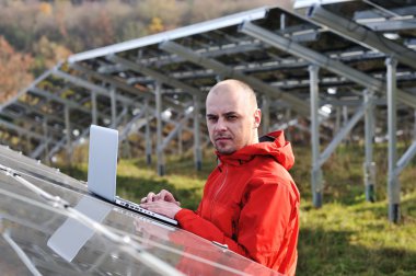 erkek mühendis dizüstü, güneş panelleri arka planı olarak kullanma