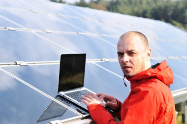 erkek mühendis dizüstü, güneş panelleri arka planı olarak kullanma