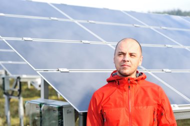 arka planda güneş panelleri ile genç bir erkek işçi