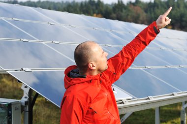 erkek mühendis olarak iş yeri, arka planda güneş panelleri