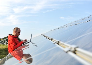 erkek mühendis olarak iş yeri, arka planda güneş panelleri