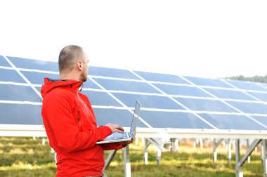 erkek mühendis dizüstü, güneş panelleri arka planı olarak kullanma