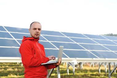 erkek mühendis dizüstü, güneş panelleri arka planı olarak kullanma