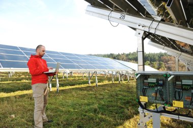 erkek mühendis dizüstü, güneş panelleri arka planı olarak kullanma