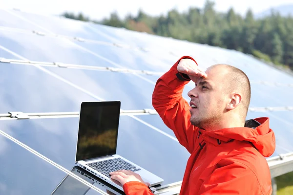 Erkek mühendis olarak iş yeri, arka planda güneş panelleri — Stok fotoğraf