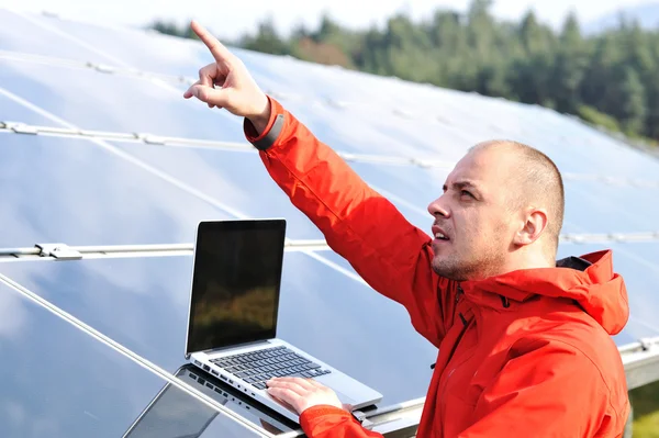 Ingénieur masculin utilisant un ordinateur portable, panneaux solaires en arrière-plan — Photo