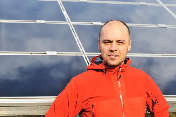 Joven ingeniero masculino con paneles solares en segundo plano —  Fotos de Stock