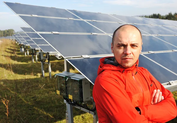Arka planda güneş panelleri ile genç bir erkek mühendis — Stok fotoğraf