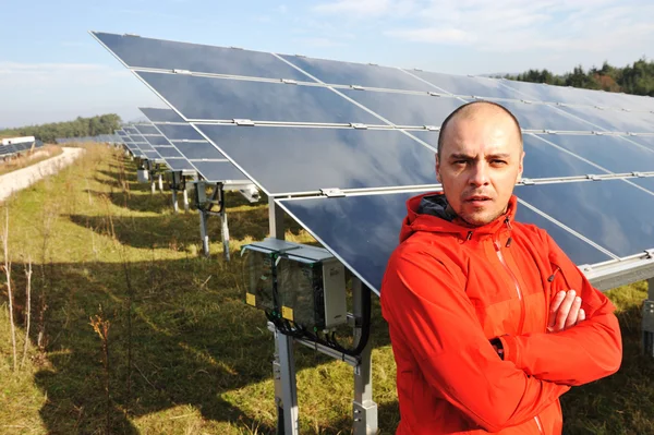 Joven ingeniero masculino con paneles solares en segundo plano — Foto de Stock