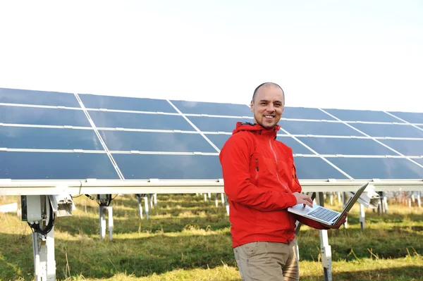 Ingenieur mit Laptop, Solarzellen im Hintergrund — Stockfoto