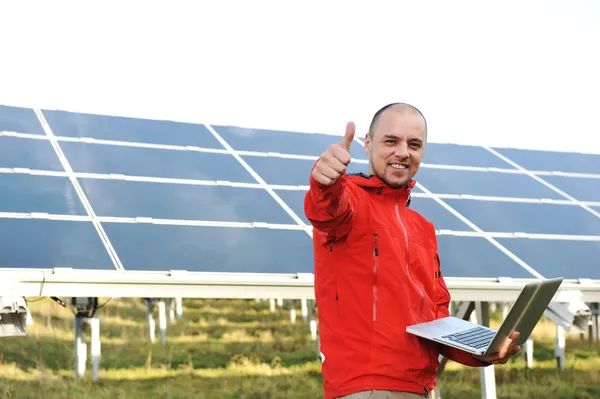 Erkek mühendis dizüstü, güneş panelleri arka planı olarak kullanma — Stok fotoğraf