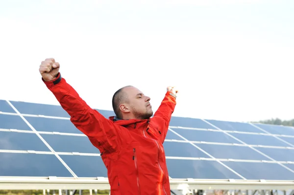 Sucesso, engenheiro em campos de painéis solares abrindo os braços — Fotografia de Stock