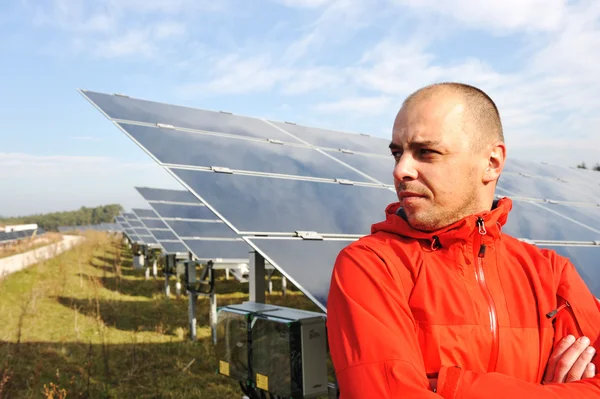 Young male engineer with solar panels in background Stock Image