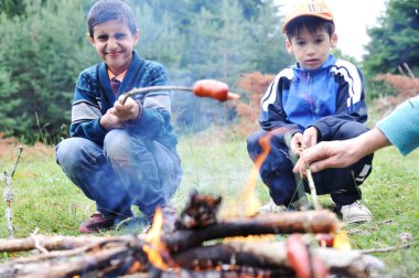 Barbekü doğada, sosisler yanıyor hazırlama grubu (Not: sığ dof)