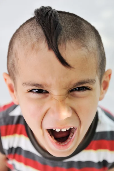 Menino bonito com cabelo engraçado e grimace alegre — Fotografia de Stock