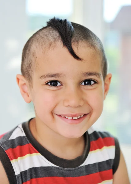 Menino bonito com cabelo engraçado e grimace alegre — Fotografia de Stock