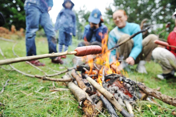 Grill w przyrodzie, Grupa przygotowania kiełbasy na ogień (Uwaga: płytkie dof) — Zdjęcie stockowe