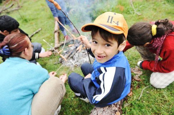 Barbacoa en la naturaleza, grupo de niños preparando salchichas en llamas — Foto de Stock