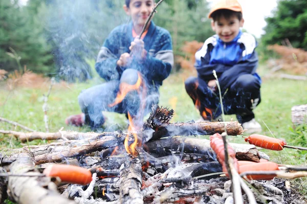 Barbacoa en plena naturaleza, grupo de salchichas preparadas al fuego (nota: dof poco profundo ) Imágenes De Stock Sin Royalties Gratis