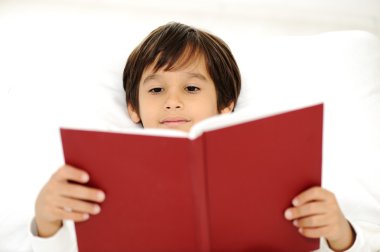 çocuğun yatakta kitap okumak