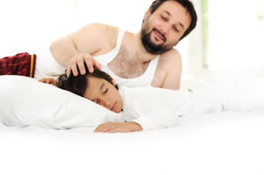 Baba ve oğul yatakta mutlu saat