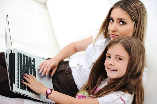 Mother and daugther with laptop on sofa — Stock Photo, Image