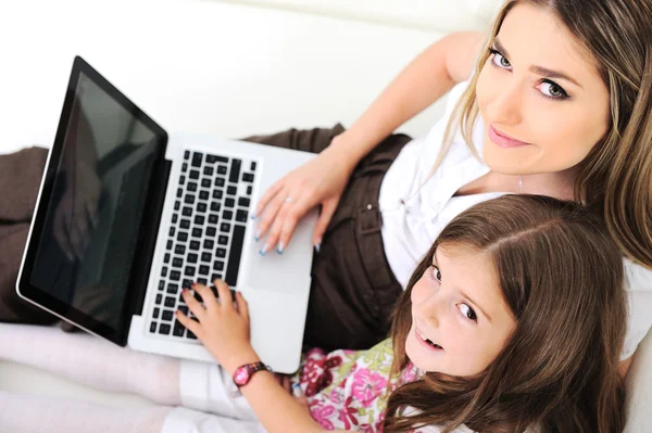 母亲和小孩儿的用在沙发上的笔记本电脑 — 图库照片