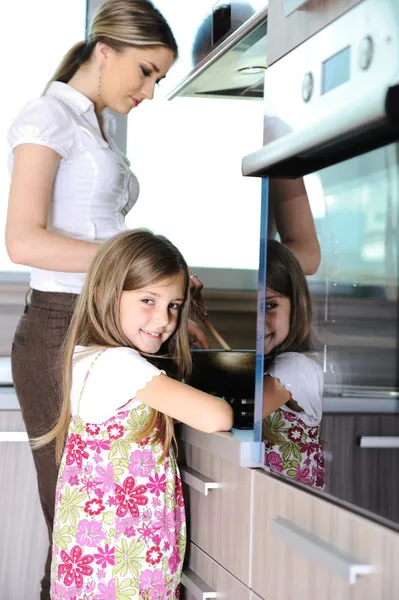 Giovane madre e bambina figlia in cucina — Foto Stock