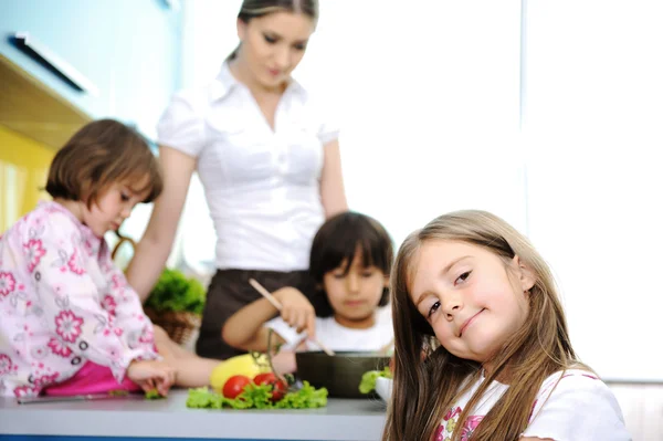 Lycklig familj i köket, mamma och barn matlagning tillsammans — Stockfoto