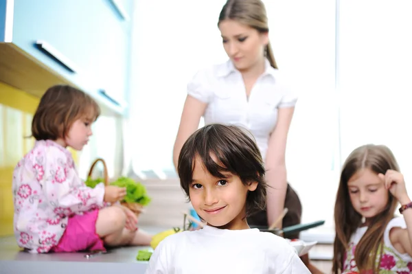 Bonne famille dans la cuisine, mère et enfants cuisinent ensemble — Photo