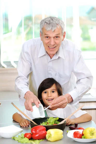 Grandfather and little boy in kitchen cooking together — Stock Photo, Image