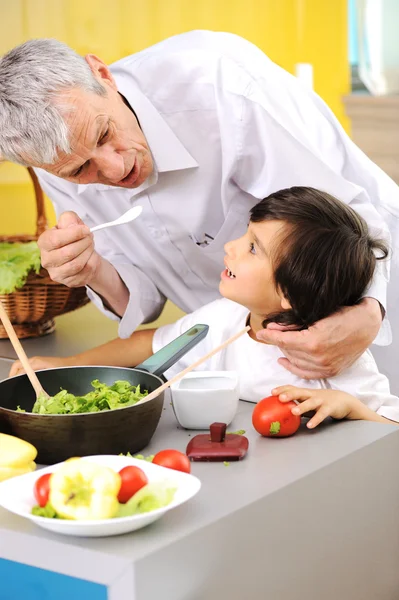 Farfar och liten pojke i kök matlagning tillsammans — Stockfoto