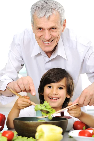 Grandfather and little boy in kitchen cooking together — Stock Photo, Image