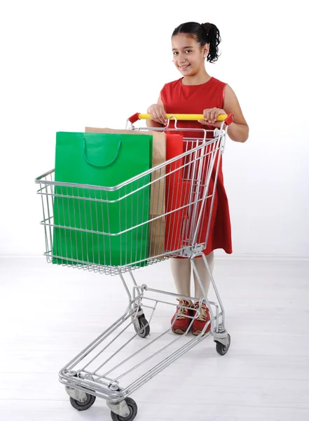 Alışveriş sepeti ile Kırmızı elbiseli küçük kız alışveriş — Stok fotoğraf