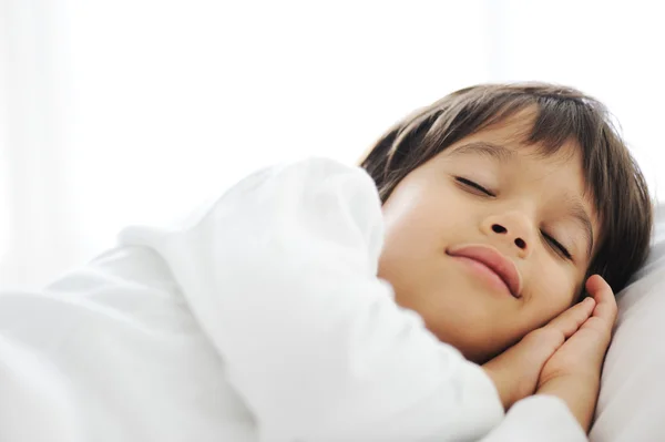 Niño en la cama de dormir, la hora de dormir feliz en el dormitorio blanco —  Fotos de Stock