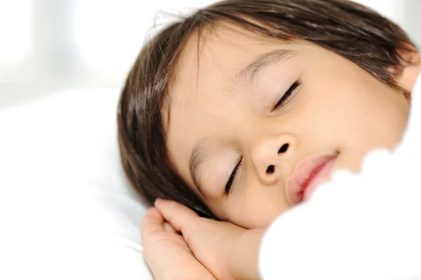 Niño en la cama de dormir, la hora de dormir feliz en el dormitorio blanco —  Fotos de Stock