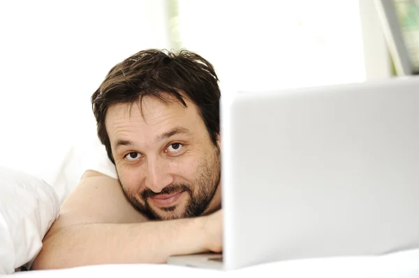 Άνθρωπος στον ύπνο κρεβάτι χρησιμοποιώντας φορητό υπολογιστή — Φωτογραφία Αρχείου