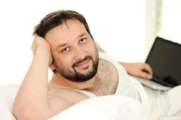 Hombre en la cama de dormir usando el ordenador portátil — Foto de Stock